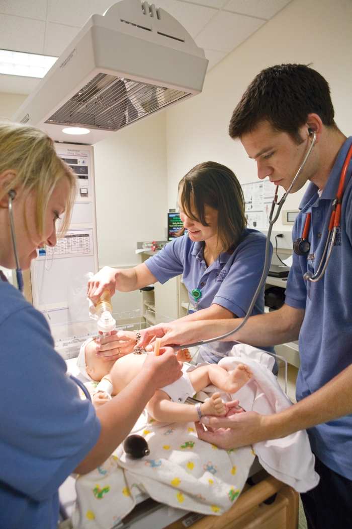 Nursing students work on a simulation baby